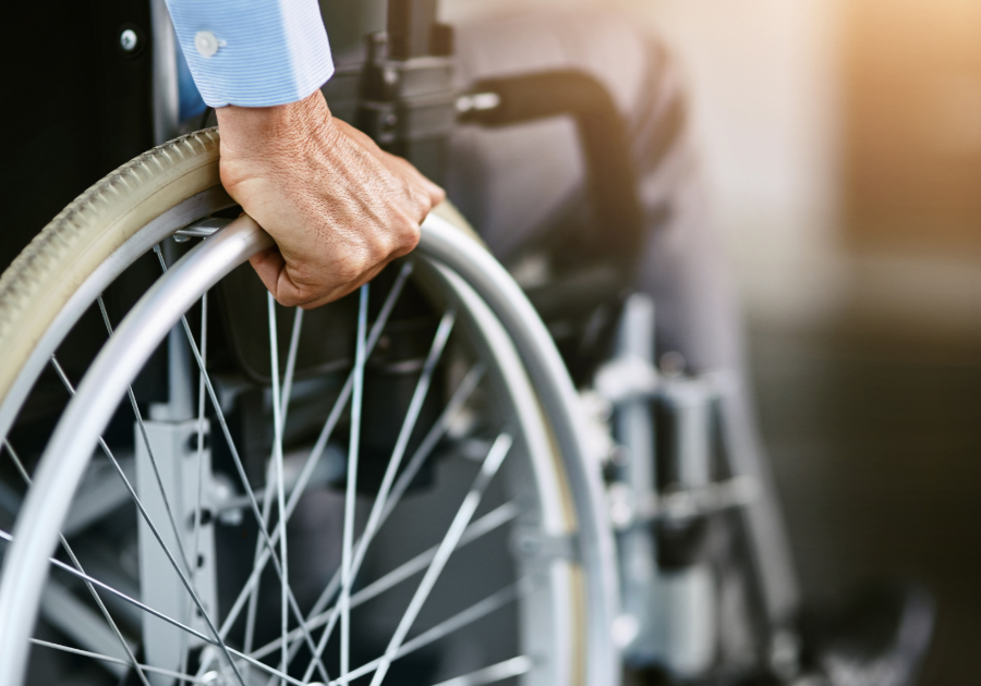 Person with hand on wheelchair wheel