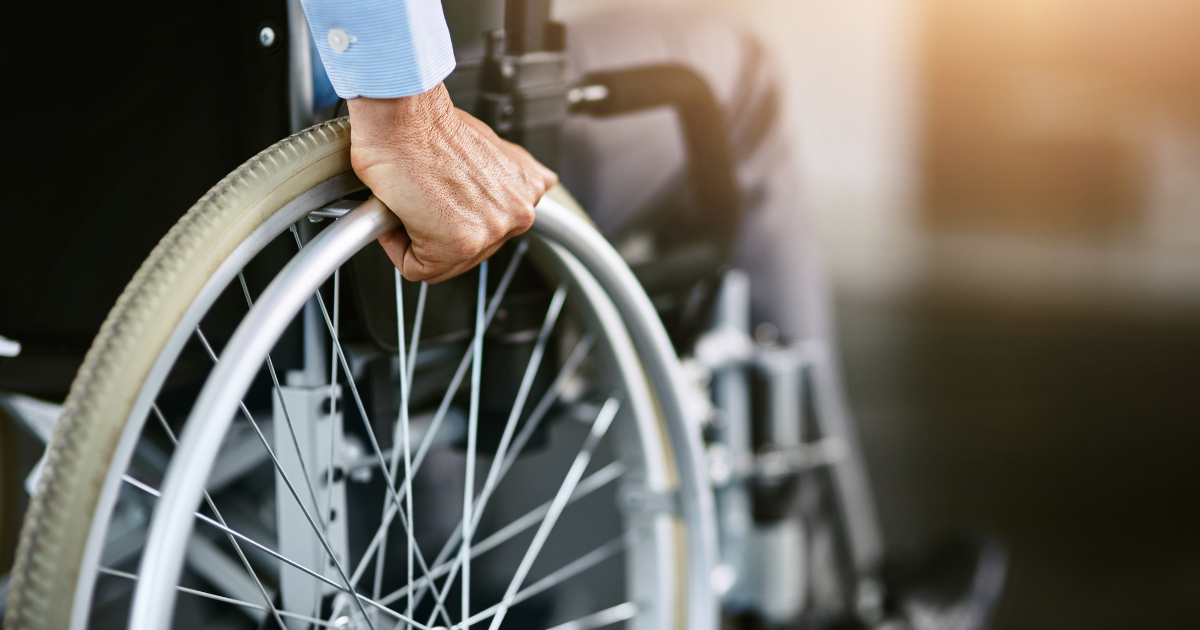Person with hand on wheelchair wheel