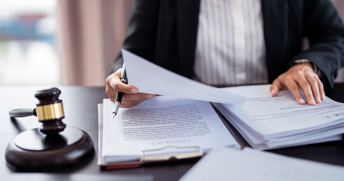 person at desk with documents and gavel